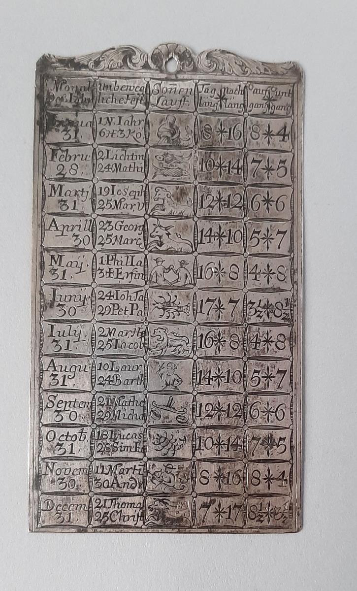 eine von zwei Deckplatten eines Notizbüchleins in Gestalt eines immerwährenden Kalenders
