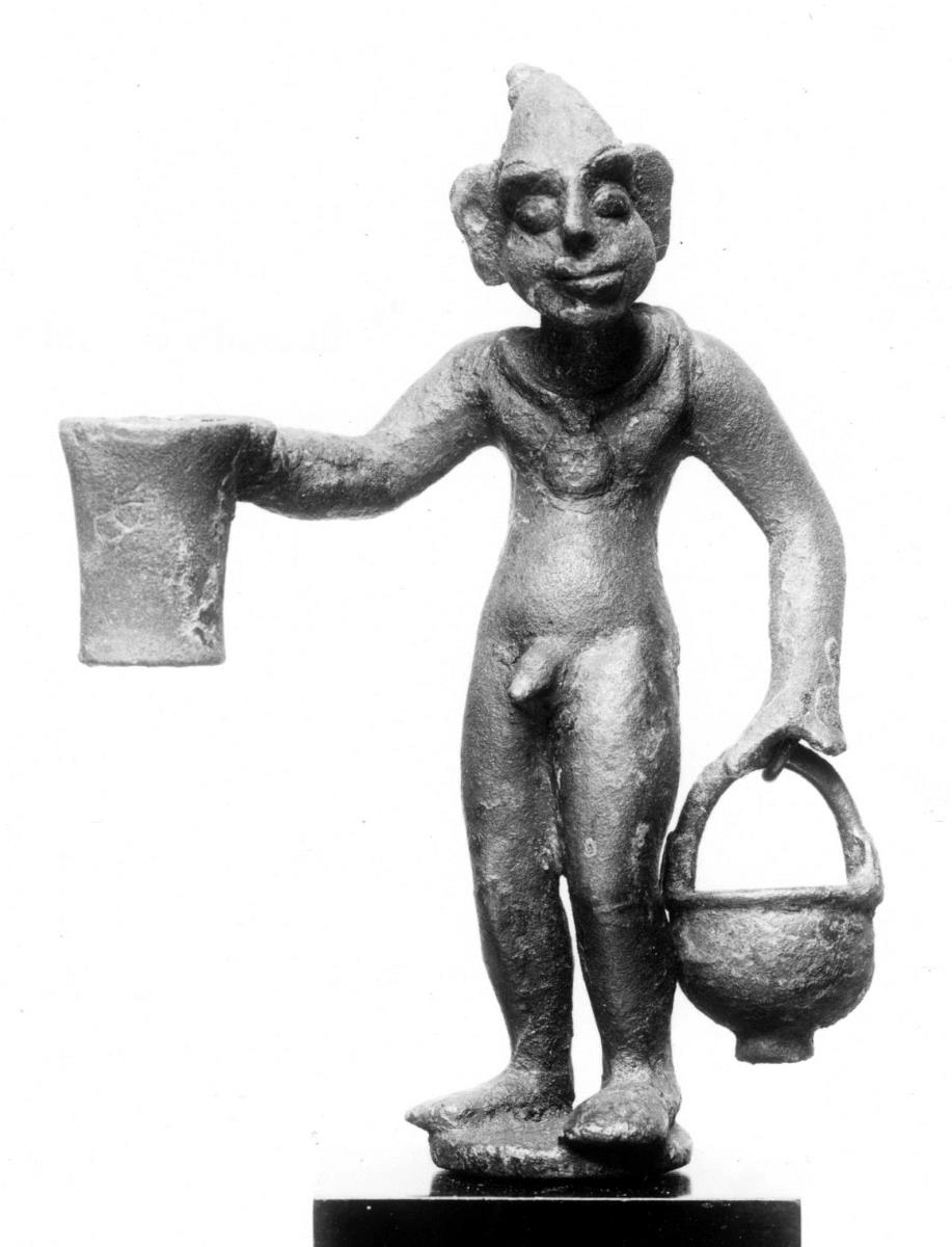 Koptische Statuette eine grotesken nackten Mannes mit Haarschopf, auf runder Basis stehend, die einen Dorn zum Einsetzen hat. Bulla um den Hals, und Sack auf dem Rücken. ...