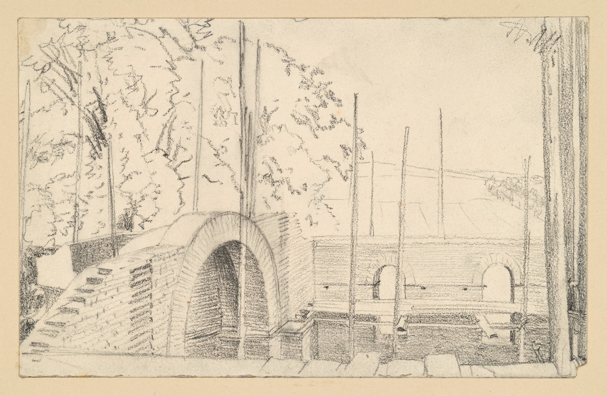 Rohbau mit Gerüst, dahinter Blick auf Bäume und Landschaft
