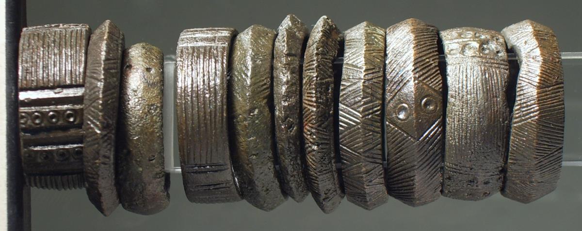 Einer von elf Ringen mit Strichmusterung und zum Teil mit kleinen Kreisornamenten