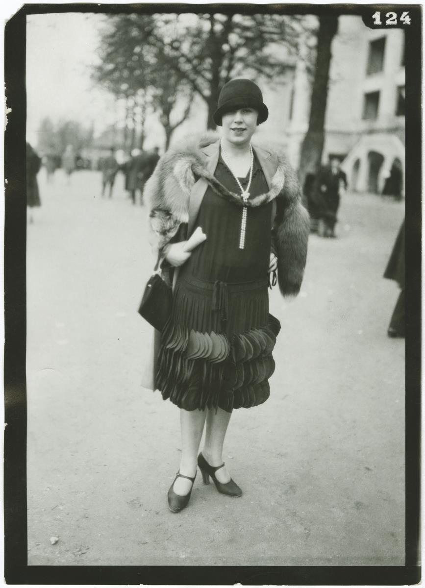 Frau in Kleid und Mantel auf dem Rennplatz in Auteuil