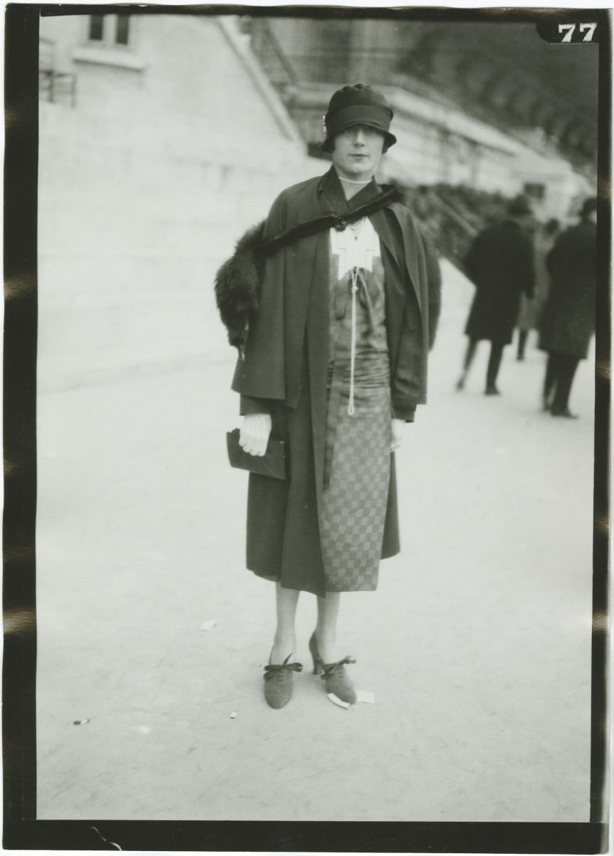 Frau in Kleid und Mantel auf dem Rennplatz in Auteuil