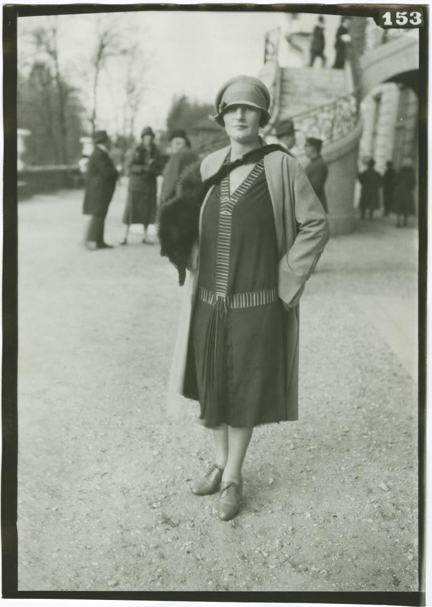 Frau in Kleid und Mantel auf dem Rennplatz in Auteuil