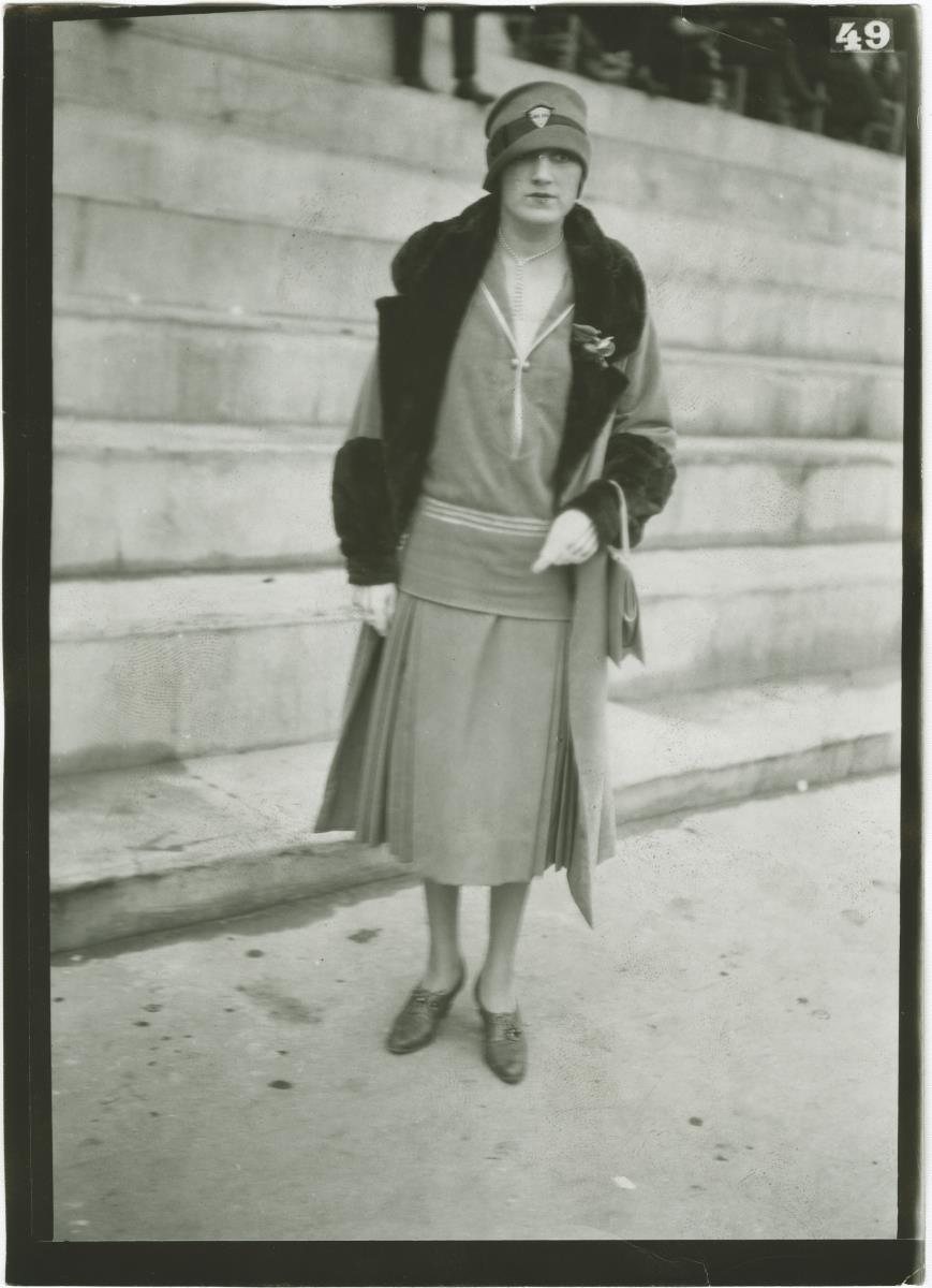 Frau in Kleid und Mantel auf dem Rennplatz in Auteuil