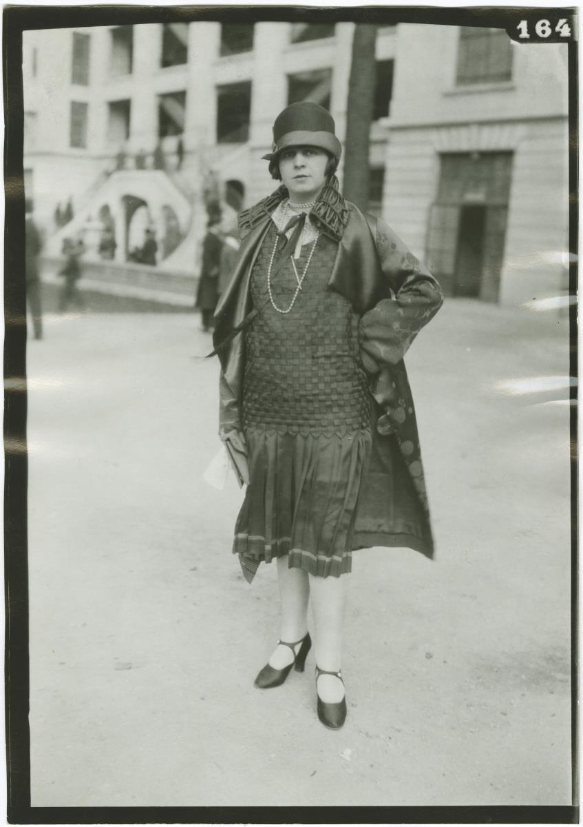 Frau in Kleid und Mantel auf dem Rennplatz in Auteuil