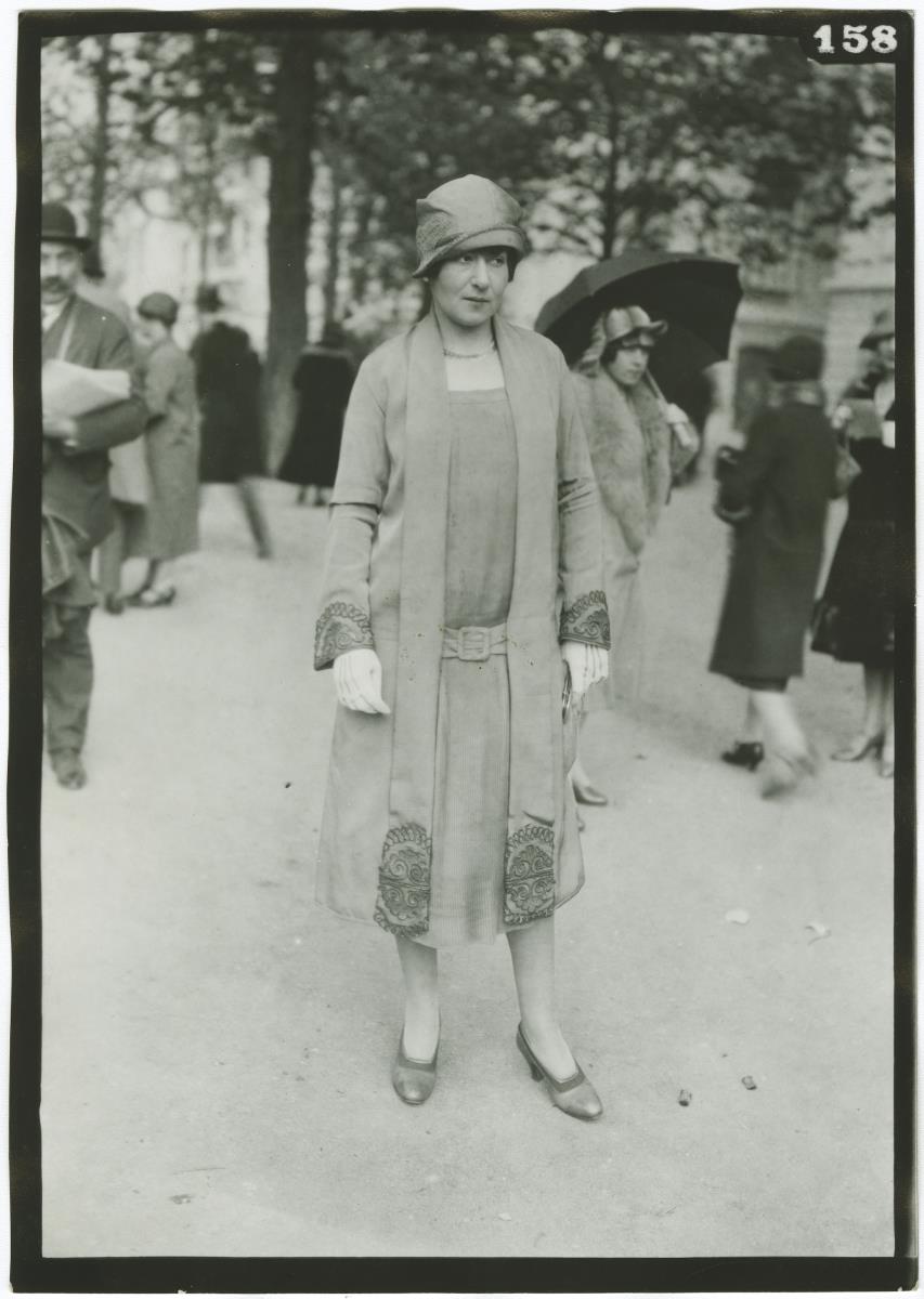 Frau in Kleid und Mantel auf dem Rennplatz in Auteuil