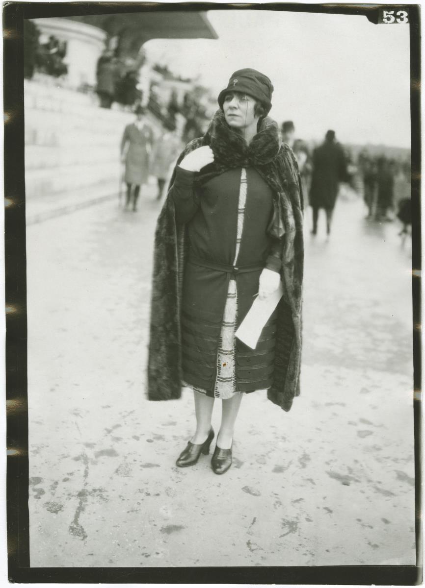 Frau in Kleid und Mantel auf dem Rennplatz in Auteuil