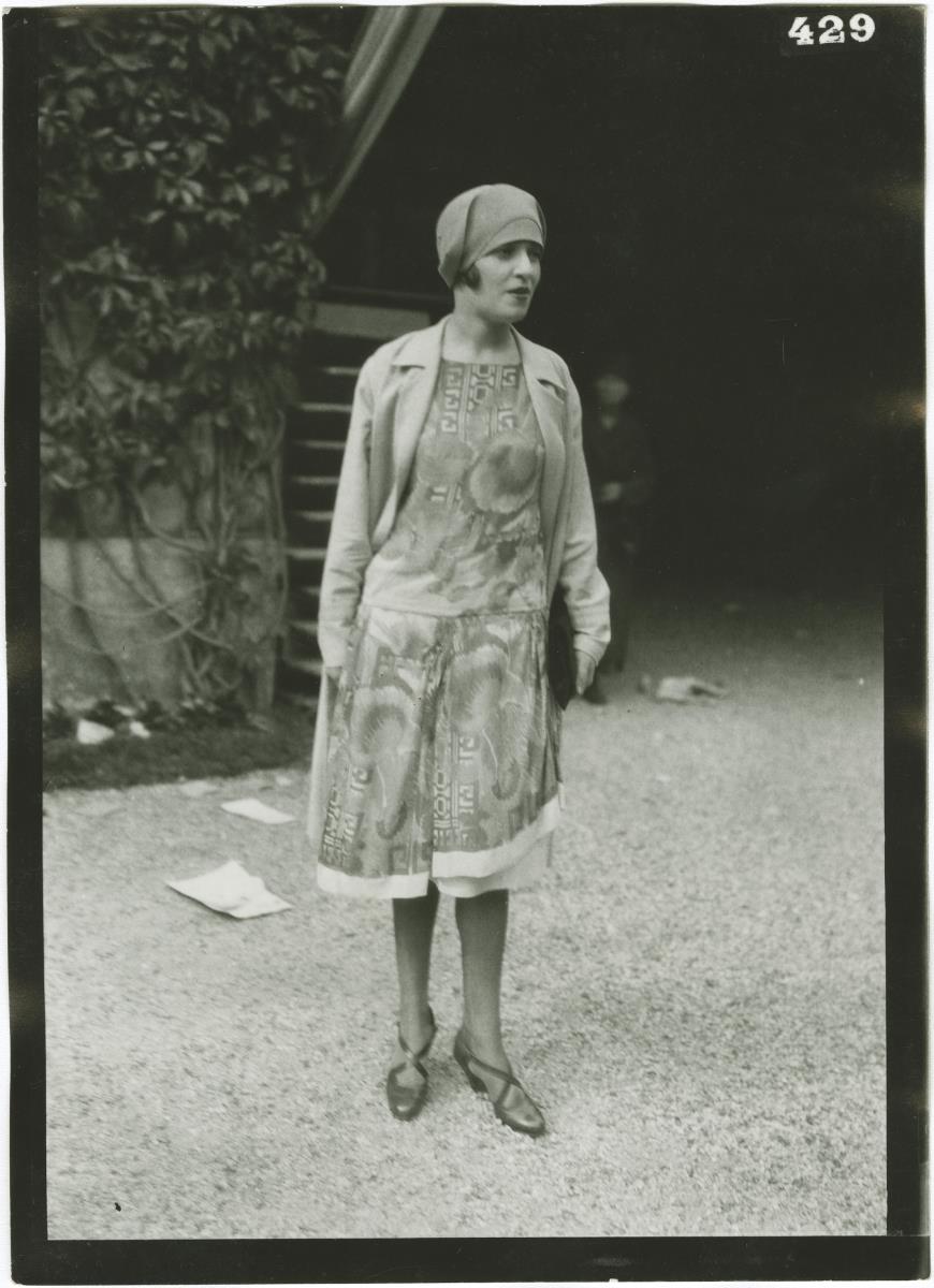 Frau in Kleid und Mantel auf dem Rennplatz in Chantilly