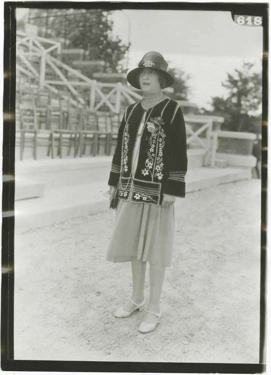 Frau in Kleid und Jacke auf dem Rennplatz in Deauville