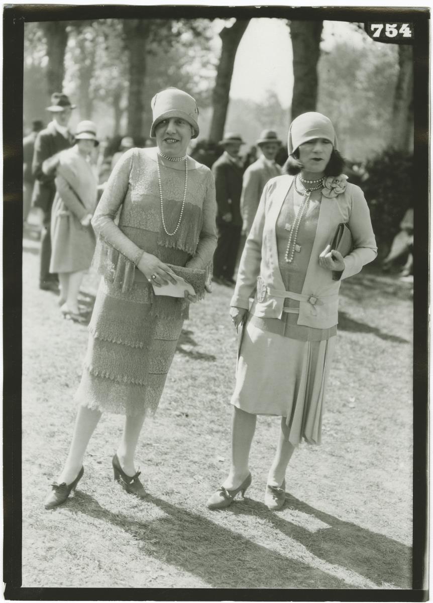 Frau in Kleid und Frau in Kostüm auf dem Rennplatz in Deauville