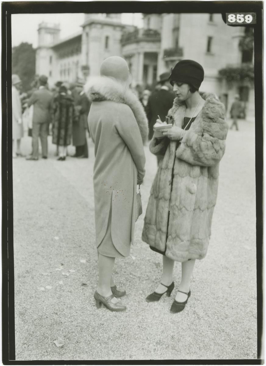 Frauen in Mänteln auf dem Rennplatz in Longchamp