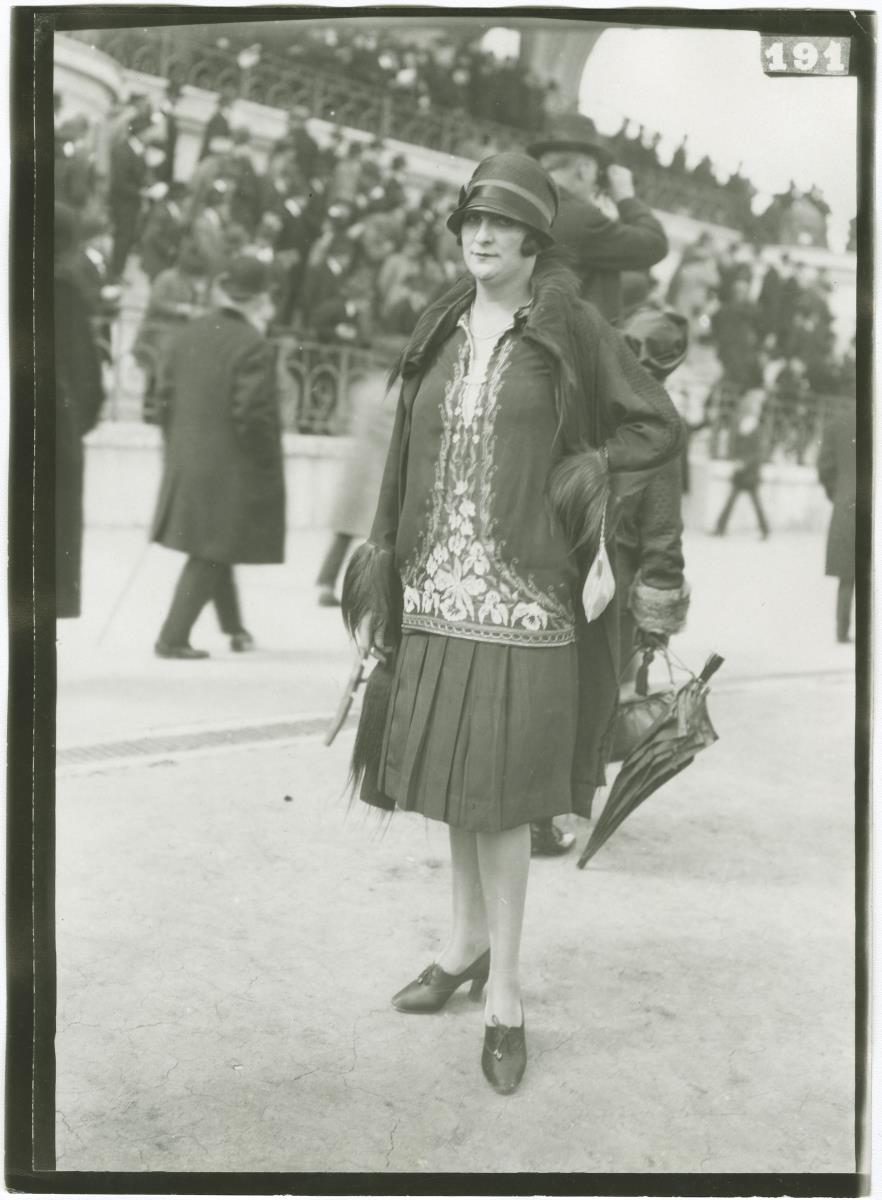 Frau in Kleid und Mantel auf dem Rennplatz in Auteuil