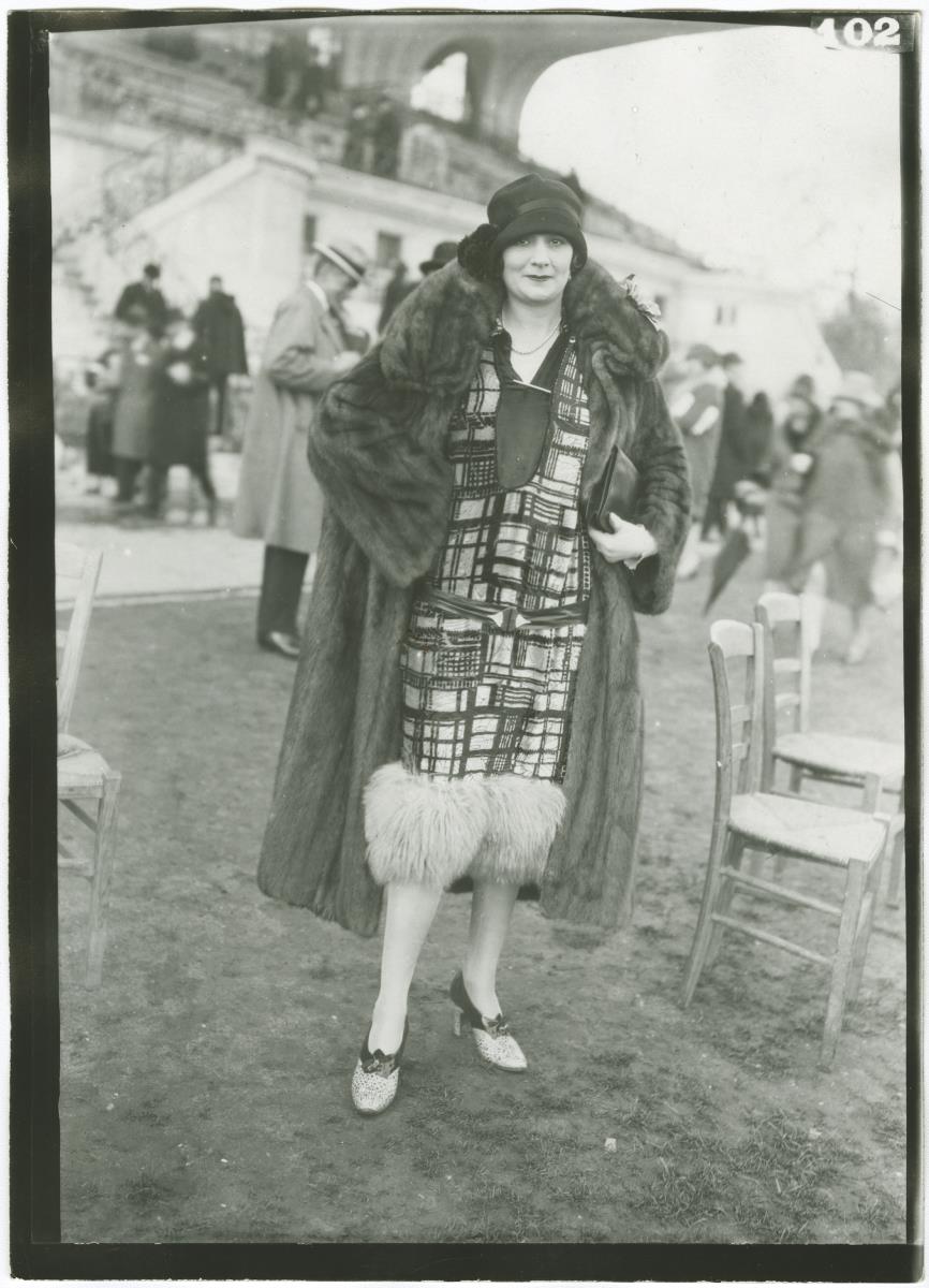 Frau in Kleid und Mantel auf dem Rennplatz in Auteuil