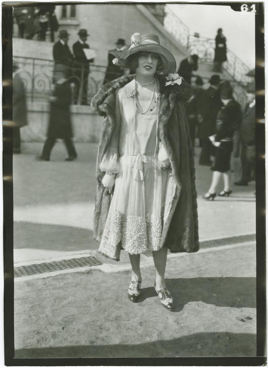 Frau in Kleid und Mantel auf dem Rennplatz in Auteuil