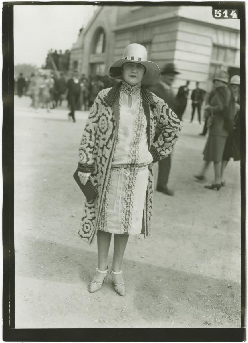 Frau in Kleid und Mantel auf dem Rennplatz in Auteuil