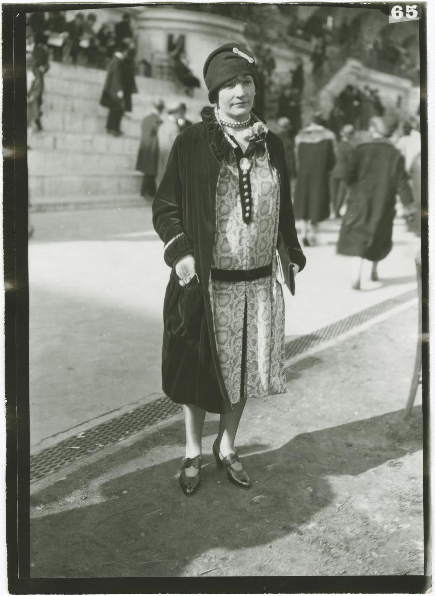 Frau in Kleid und Mantel auf dem Rennplatz in Auteuil
