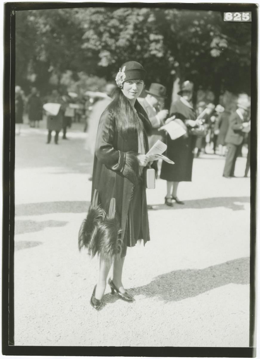 Frau in Mantel auf dem Rennplatz in Longchamp