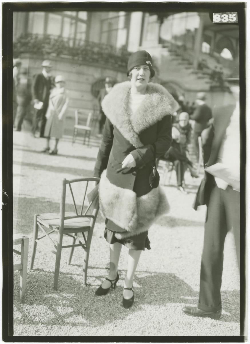 Frau in Mantel auf dem Rennplatz in Longchamp