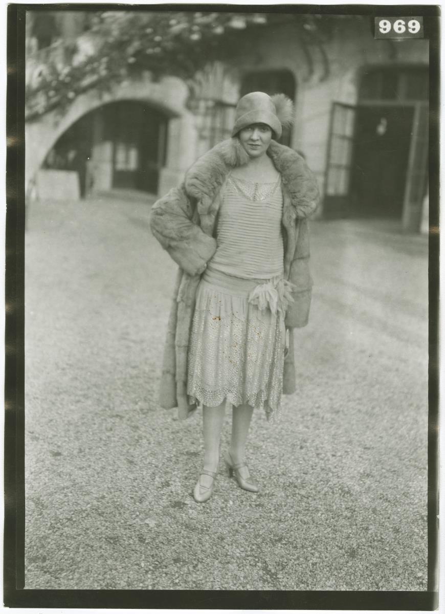 Frau in Kleid und Mantel auf dem Rennplatz in Longchamp