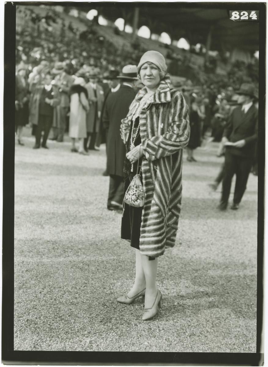 Frau in Mantel auf dem Rennplatz in Longchamp