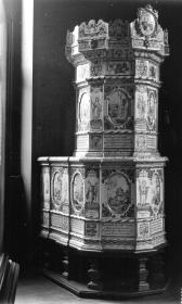 Kachelofen mit Apostelfiguren und mehrfigurigen biblischen Szenen in Landschaften mit Spruchbändern